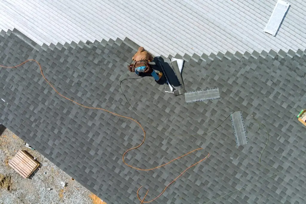 A roofer professional installing shingles top view.