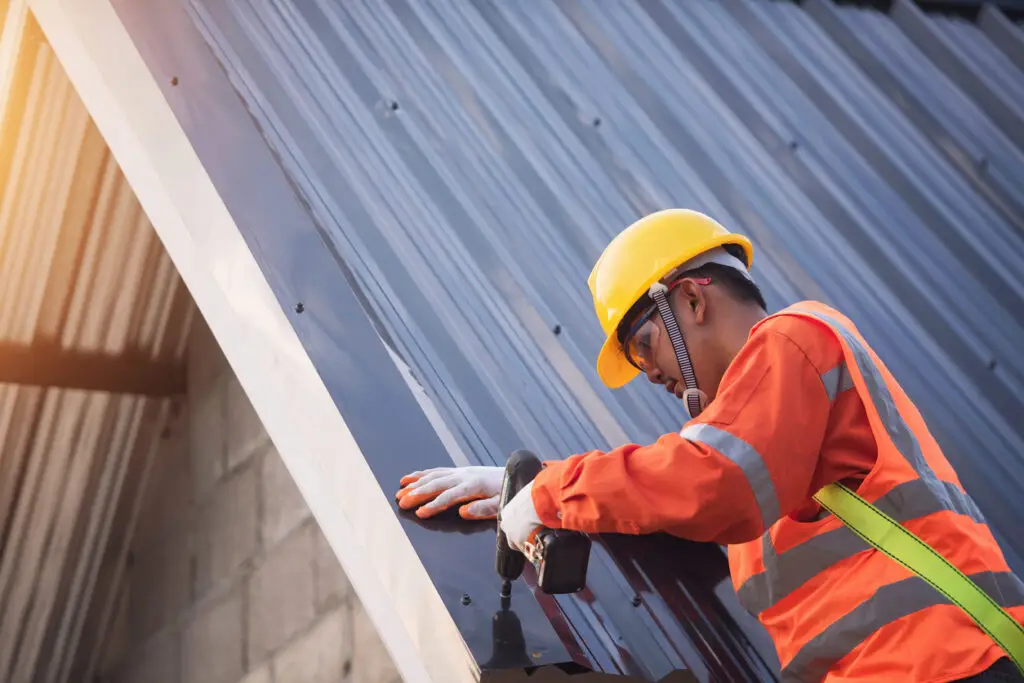 Professional metal roofing installation - A male contractor installing a residential metal roof.