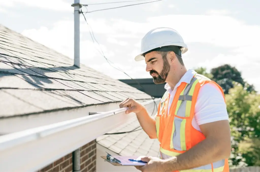 Reliable roof inspection - A male contractor inspecting a residential roof.