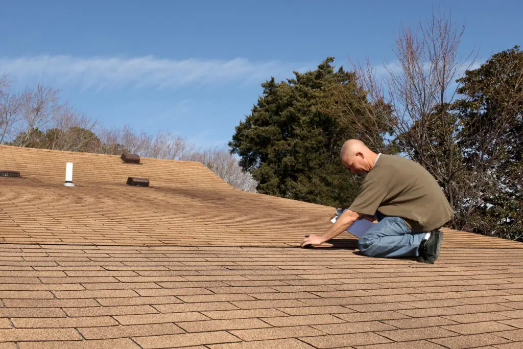 Roof inspection importance - A male contractor checking a home's roof quality.