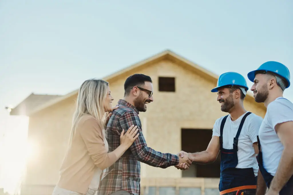 Trusted roof inspection - A couple shaking hands with roofing contractors.