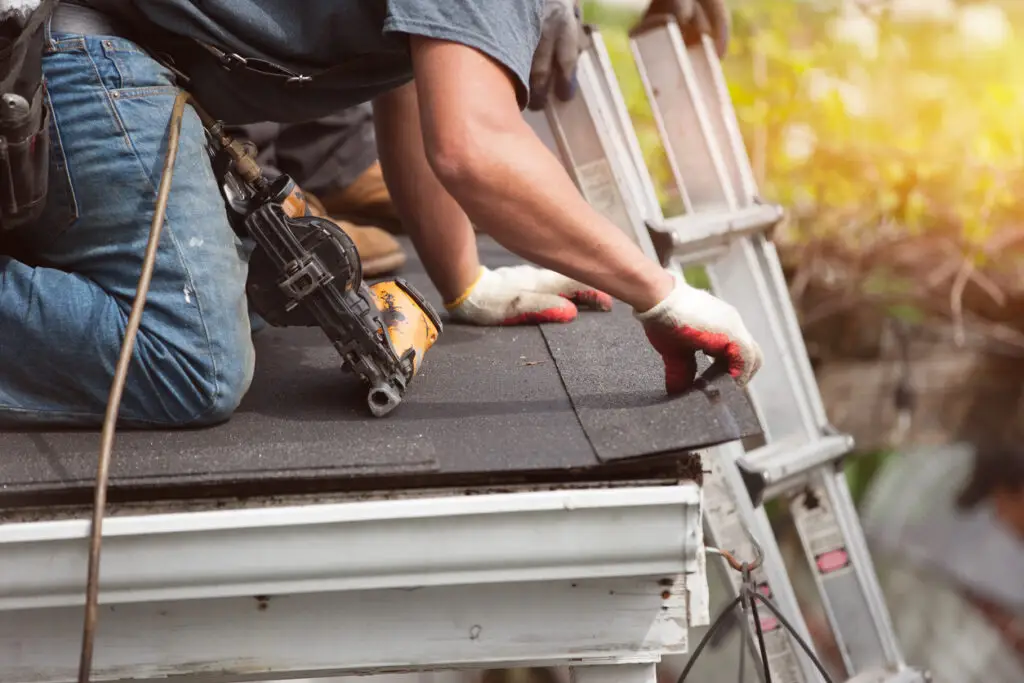 Roofer installing a new roof on a residential home.