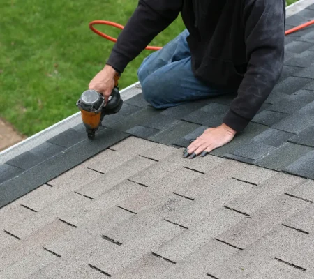 A homeowner doing DIY roof repair at his home.