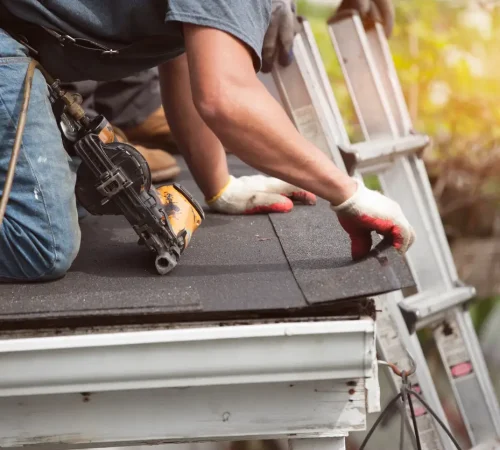 Homeowner's insurance roofing coverage - A male roofing contractor using special tools to repair a home's roofing.